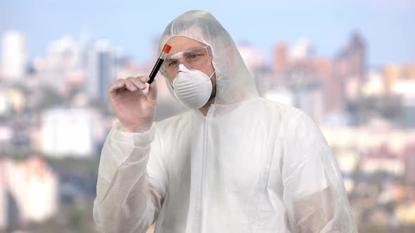Man Wearing Protective Suit and Observing Blood Test Tube alt