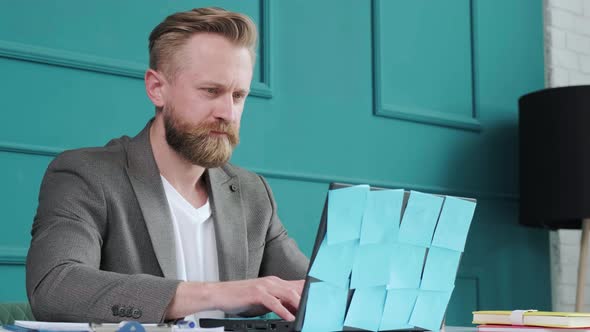 Close Up of a Bearded Man Comfortable at His Desk Typing at the Computer alt