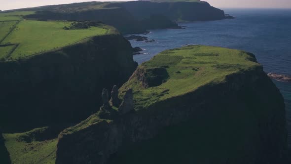 Ruins of Dunseverick Castle, Antrim Coast, Northern Ireland. Aerial drone pull away alt