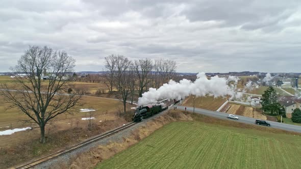 Aerial View of a Steam Train With a Drone Following Along Side Blowing Smoke and Steam Traveling alt