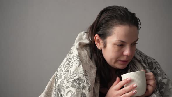 Portrait of Sick Tired Woman Patient with White Cup Sitting on Sofa