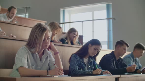 A Group of Students Listening to a Lecture at the University From a Professor alt