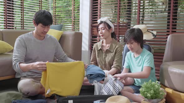 exited asian family prepare packing cloth with suitcase luggage travel