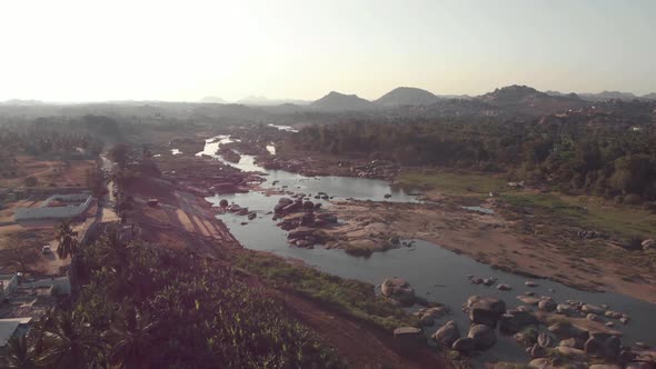 Tungabhadra River flow cascading alongside the rocky landscape Hampi town's edge in Karnataka, India alt