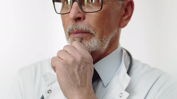 Face of an Elderly Serious Male Doctor with a Beautiful Gray Beard in Closeup alt