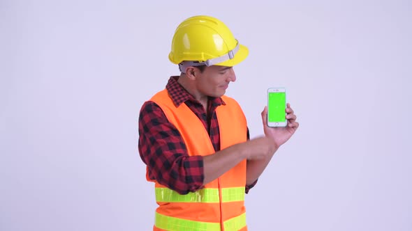 Young Happy Hispanic Man Construction Worker Showing Phone and Giving Thumbs Up