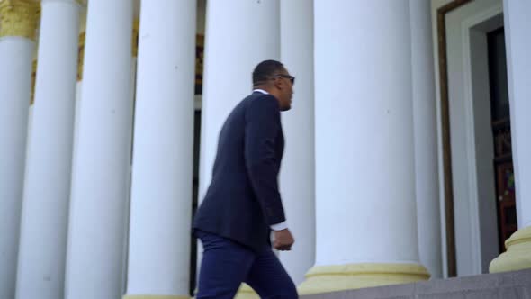 Side View of Confident African American Businessman in Elegant Suit Walking Up the Stairs Outdoors alt