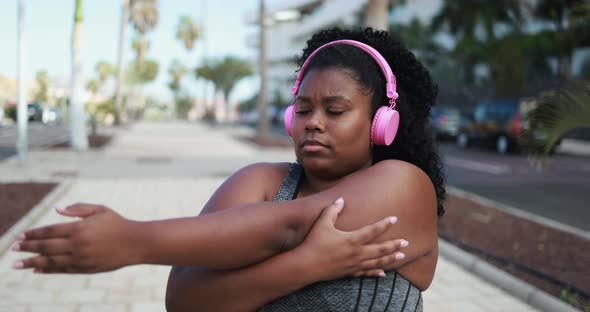 Curvy african woman doing sport stretching day routine outdoor  alt