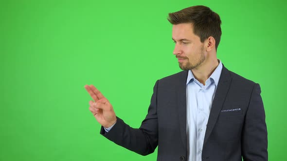 A Young Handsome Businessman Smiles and Double Clicks at a Particular Spot - Green Screen Studio alt