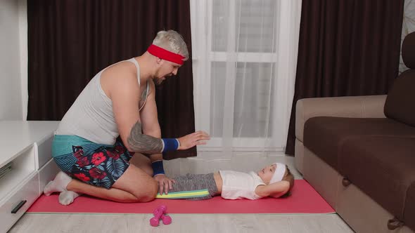 Grayhaired Bearded Sportsman Guy Trainer Father Doing Abs Exercises with Daughter at Home on Mat alt