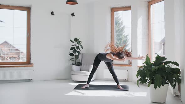 Young Sporty Brunette Girl in Sportswear Does Exercises in Bright Room at Home alt