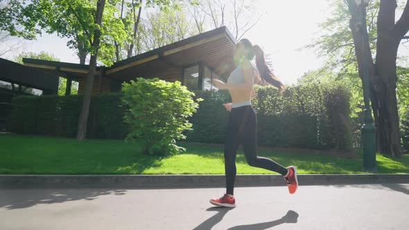 Fit Woman Jogging in Sunny Park alt