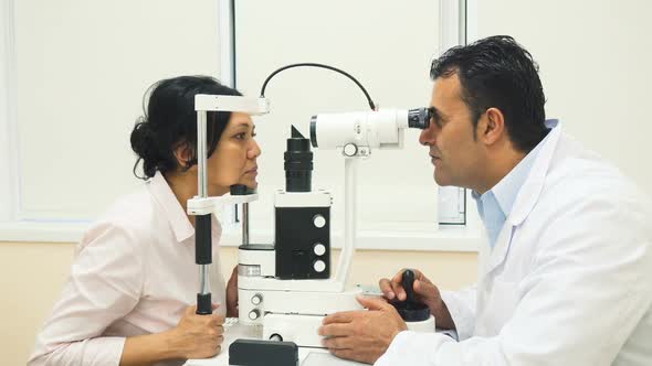A Skilled Doctor Examines the Patients Eyes with a Device alt
