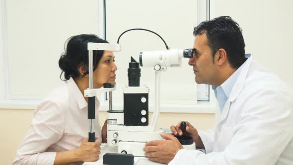 A Skilled Doctor Examines the Patients Eyes with a Device