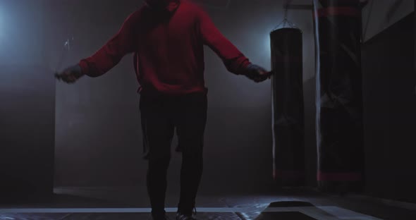 Closeup Athlete's Legs are Jumping Rope Dark Gym with Smoke alt