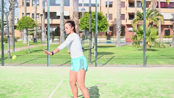 Young Woman Plays Tennis on the Field Using Racket