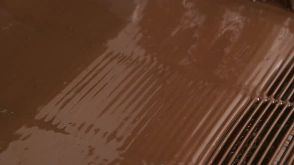 Melted chocolate pouring in a candy factory