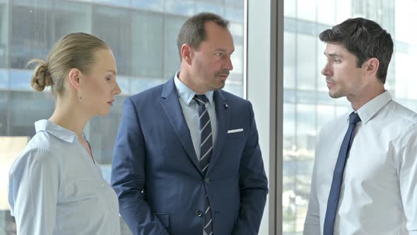 Middle Aged Manager Explaining Things To Its Assistants in Boardroom alt