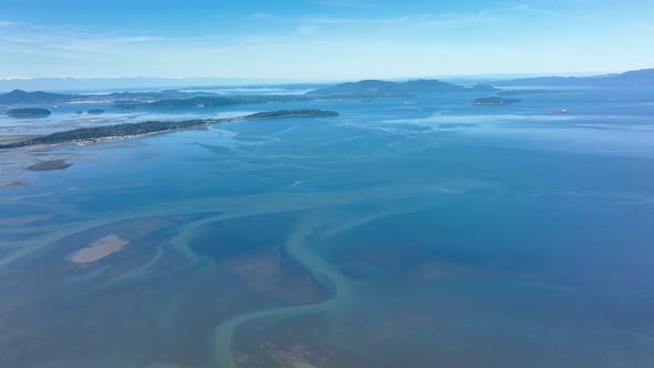Aerial shot over the water leading to the San Juan Islands. alt