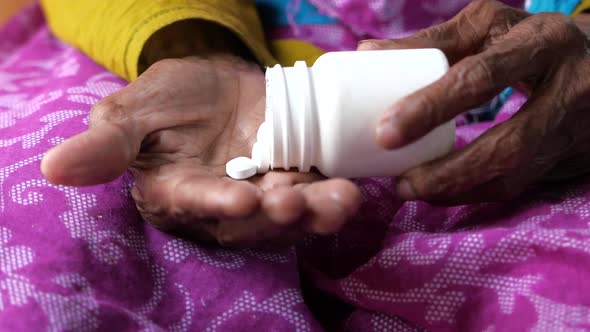 Close Up of Senior Asian Women Taking Medicine  alt