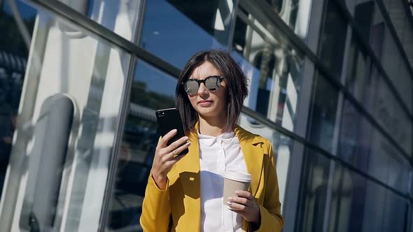 Young Professional Businesswoman in Sunglasses Standing Near Office Centre alt
