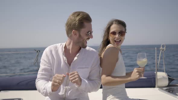 Happy Young Rich Couple Dancing on Yacht alt