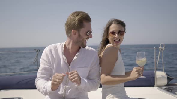 Happy Young Rich Couple Dancing on Yacht