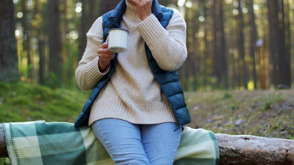 Senior Woman Drinking Tea and Eating Pie in Forest alt