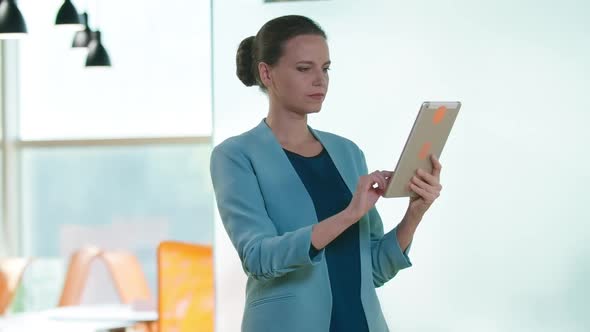 Concentrated Successful Beautiful Woman Surfing Internet on Tablet Turning Looking at Camera Smiling alt