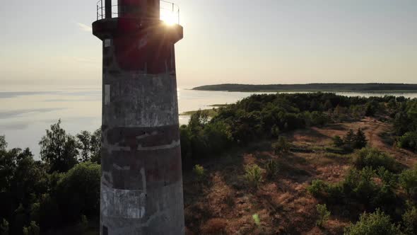 Camera fly back, show old lighthouse on small island, bright sun shine ahead
