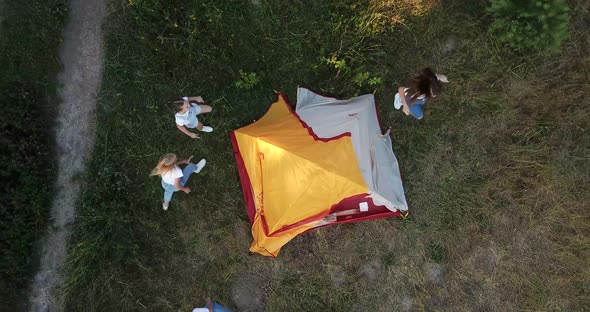 Children Run Around the Yellow Tent They are Resting Outdoors in the Woods alt