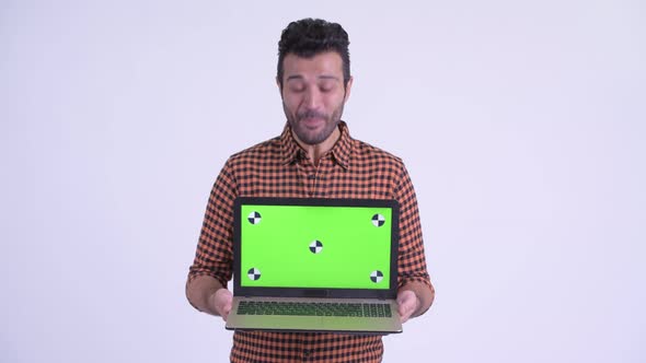 Happy Bearded Persian Hipster Man Showing Laptop and Looking Surprised alt