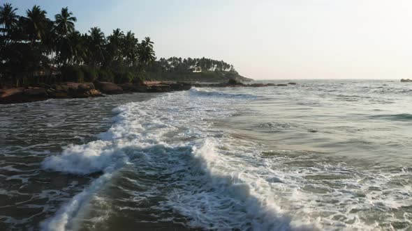 Ocean Waves on a Sandy Beach During Sunrise. View of the Beach, Ocean and Palm Trees. Sri Lanka