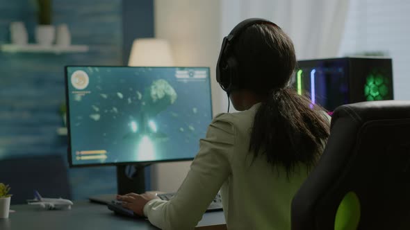 Competitive African Gamer Sitting on Gaming Chair Using Headphone alt