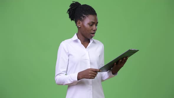 Young Beautiful African Businesswoman Reading on Clipboard