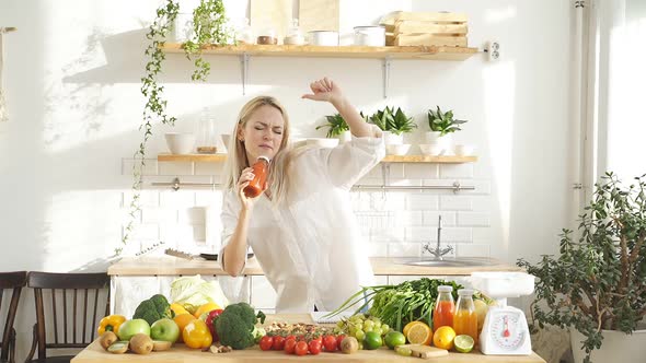 Caucasian Woman is Going to Cook Herself a Vegetable Salad in a Modern Bright Kitchen She Dances and
