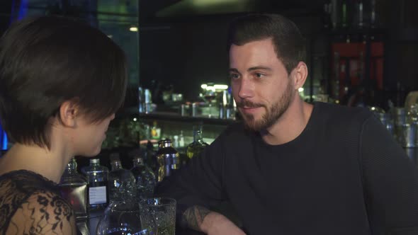 Handsome Young Man Talking To His Beautiful Girlfriend at the Bar alt