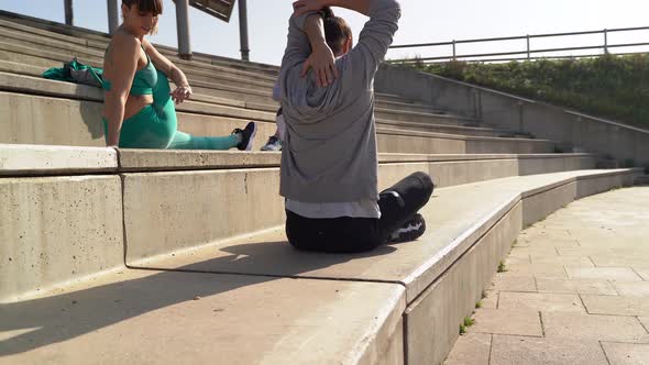 Young athletes stretching before workout on stairs alt
