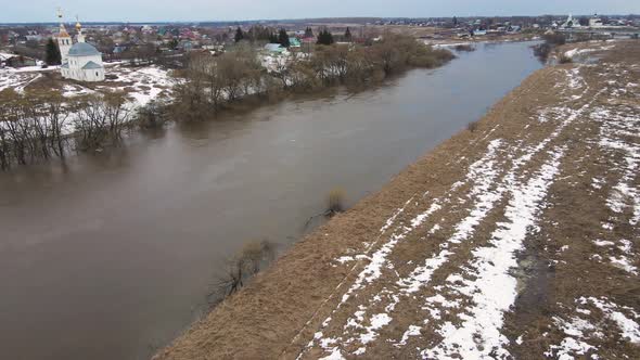 Dirty River Stream with Gray Water the Remains of Snowdrifts on the Shore alt