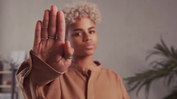 Serious Young African American Beautiful Woman Showing Stop Sign to Camera alt
