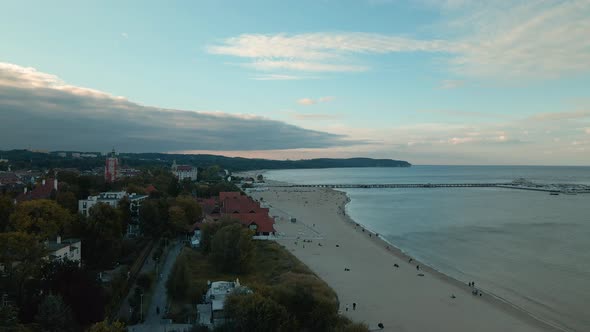 Seaside resort city and sandy beach at the coast of Baltic Sea. Aerial trucking alt