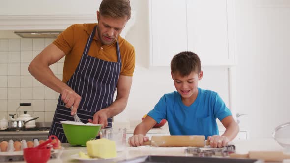Caucasian father and son baking together in the kitchen at home alt