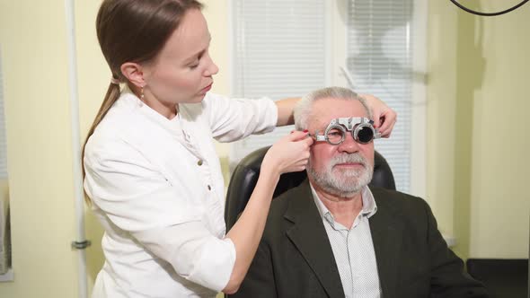 Ophthalmologist Makes Selection of Lenses Diagnoses a Elderly Man's Vision alt