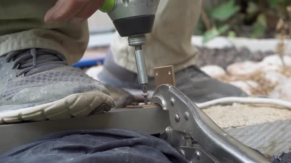 senior man hands drilling a screw outdoors close up work at home fixing