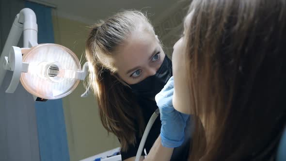 Young Woman Dentist Working with Patient's Teeth with Tools During Covid Epidemic