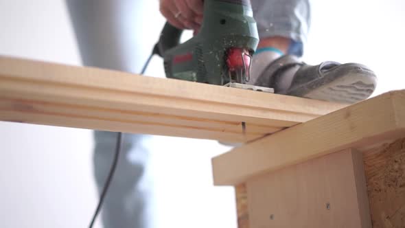 Beauty of Slow Motion in Construction and Repair - Man Sawing a Wooden Board with an Electric Jigsaw