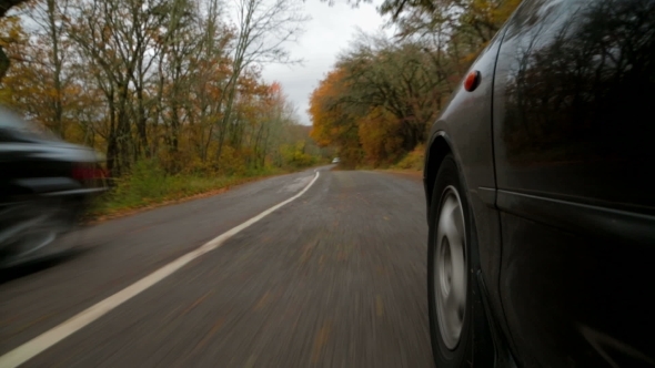 Passenger Car Moving Along Winding Road In Autumn