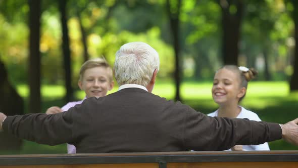 Cheerful Grandchildren Running to Their Beloved Grandfather, Hugging Back View alt