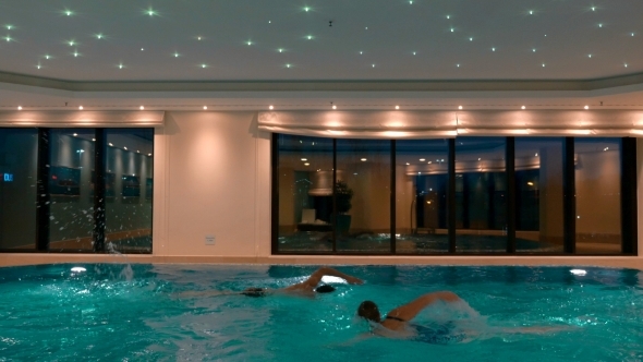 Man And Woman Swimming In The Indoor Pool By GreyCoastMedia VideoHive