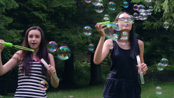 Teenage Girls Blowing Soap Bubbles in Summer Time